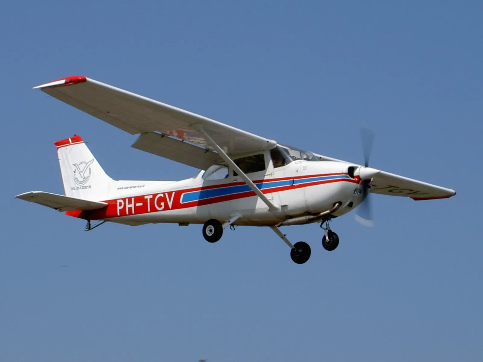 White Cessna 172 Skyhawk on airport tarmac, showing the distinctive high-wing design