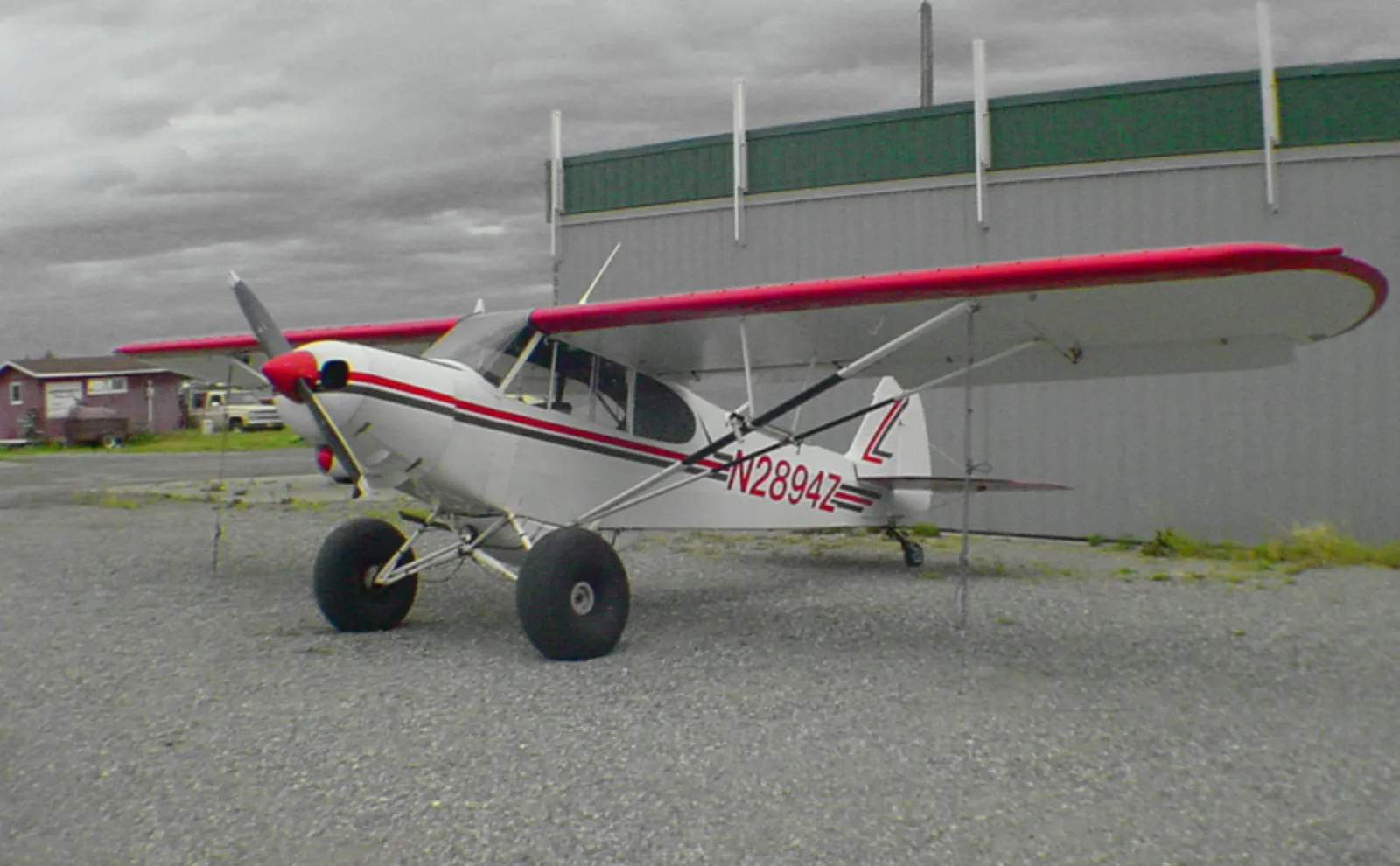 Piper Super Cub bush plane with tundra tires parked in remote Alaska wilderness