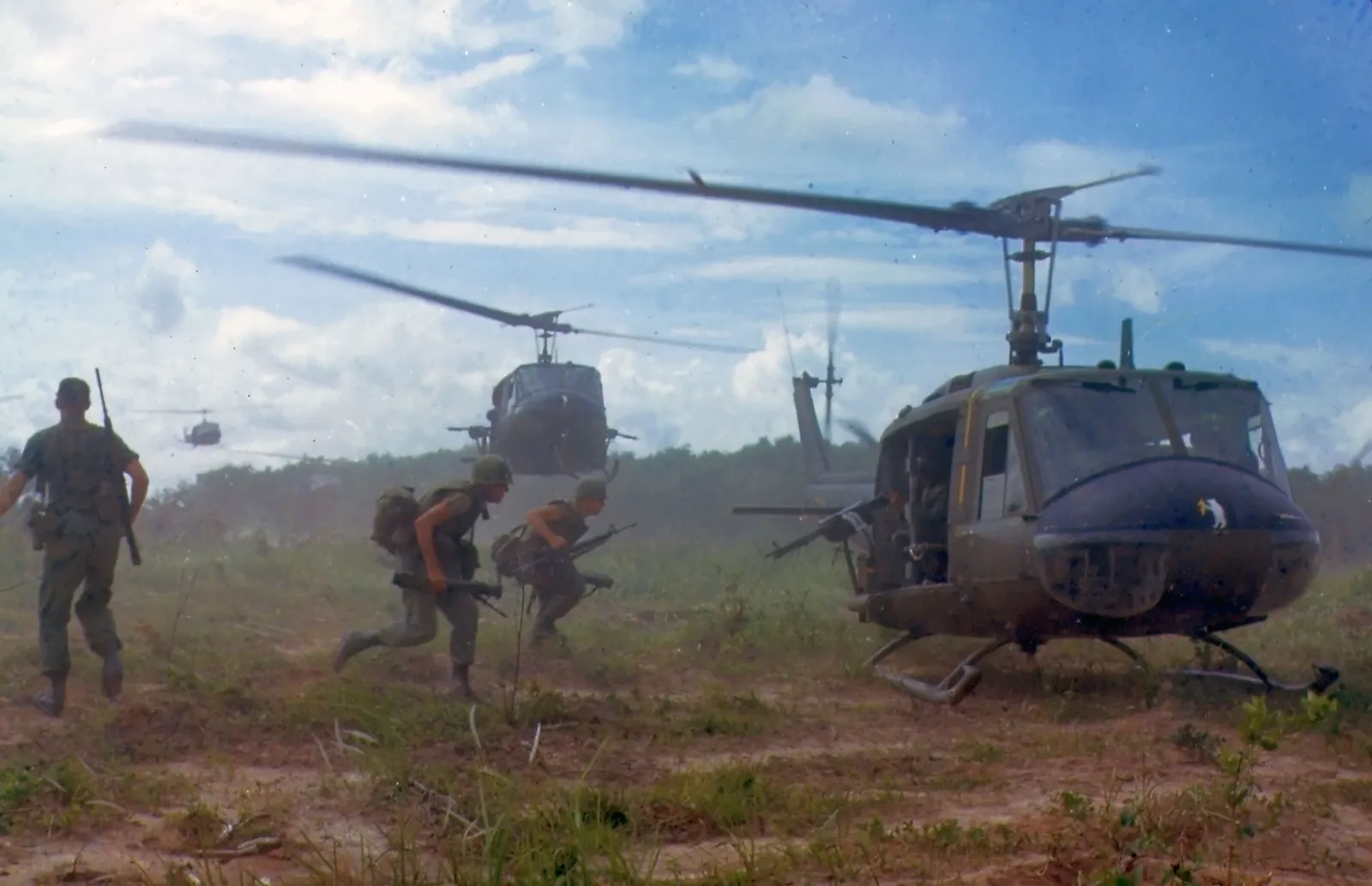 Multiple Bell UH-1D Huey helicopters flying in formation during Vietnam War operations in 1966